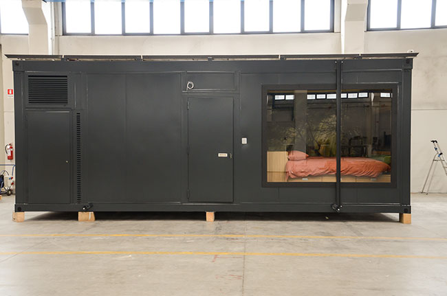 Modulo ostello prefabbricato scuro con grande vetrata