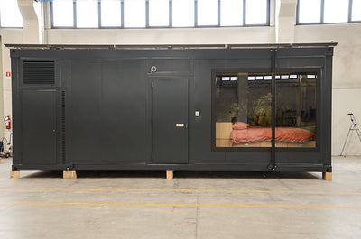 Modulo ostello prefabbricato scuro con grande vetrata